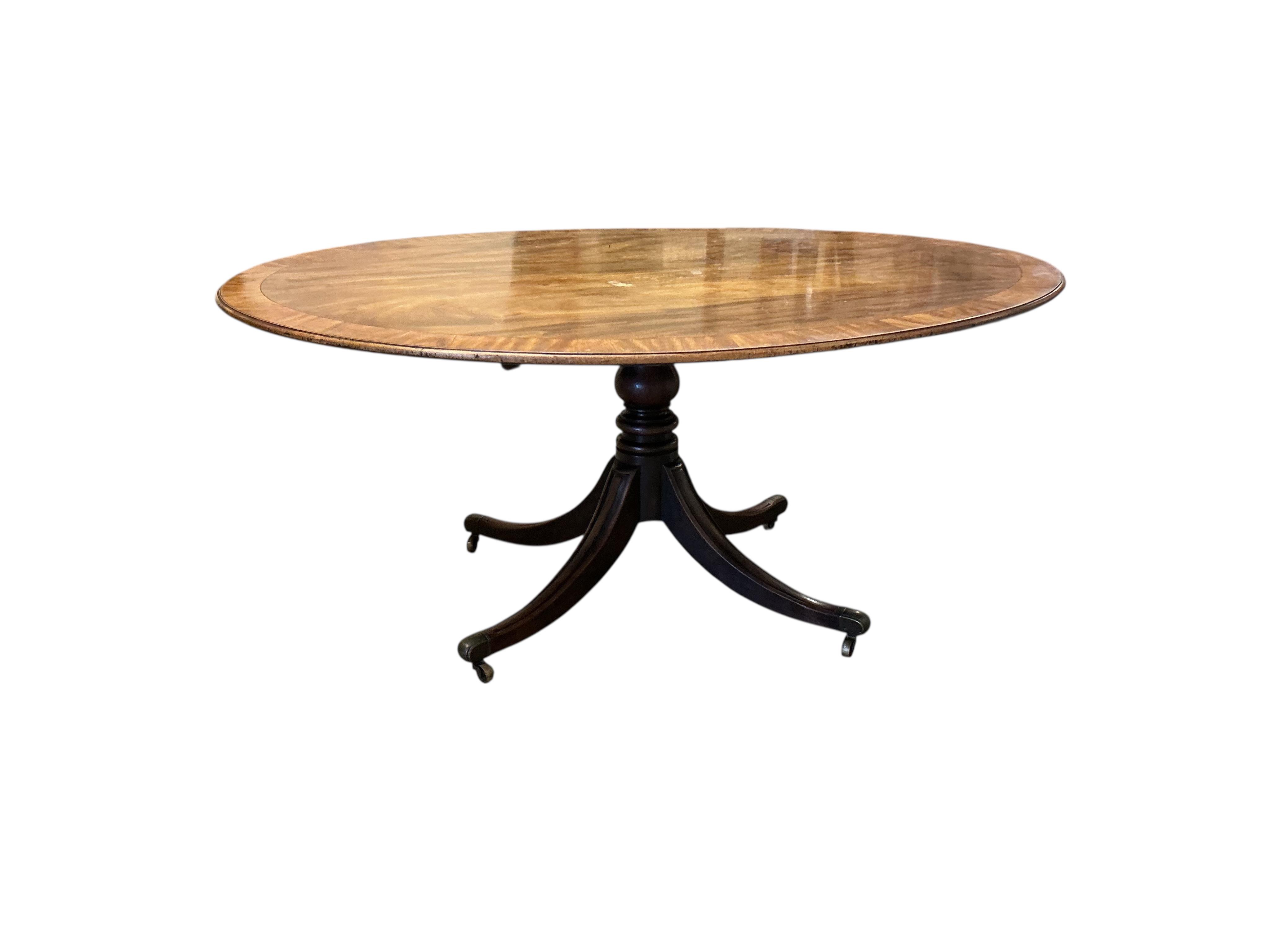 A George III banded mahogany oval tilt top dining table, width 160cm, depth 122cm, height 70cm